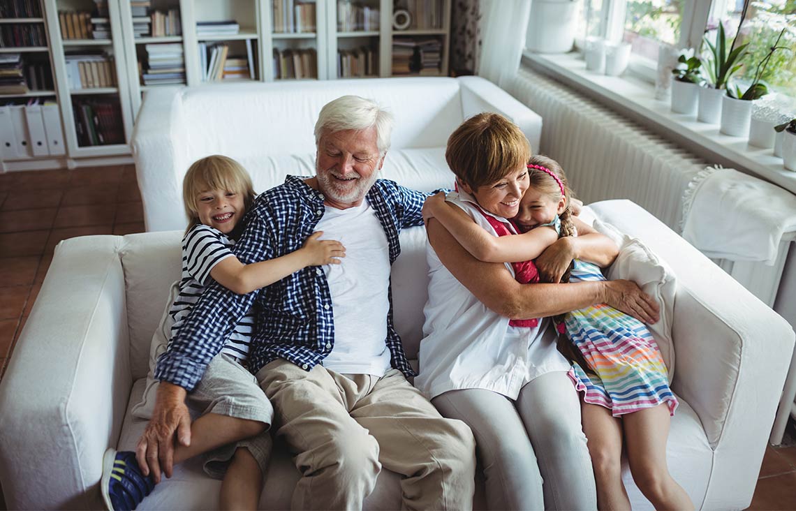 grandparents on the couch with their happy grandchildren annuity income